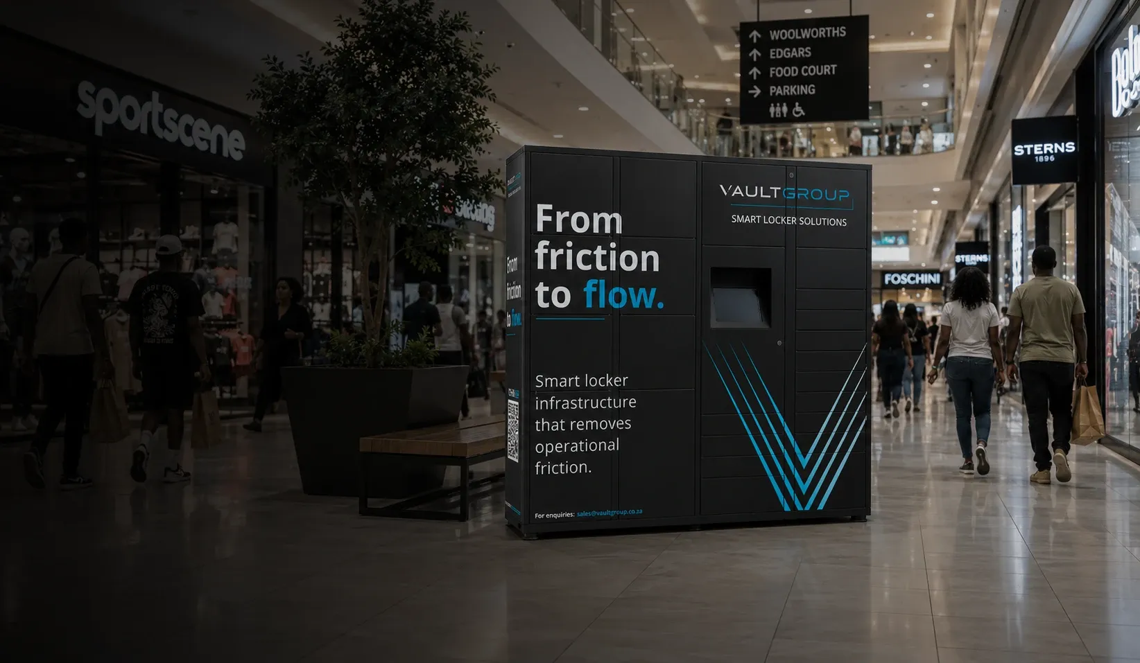 A VaultGroup smart locker unit branded From friction to flow in a shopping-mall concourse, with shoppers walking past